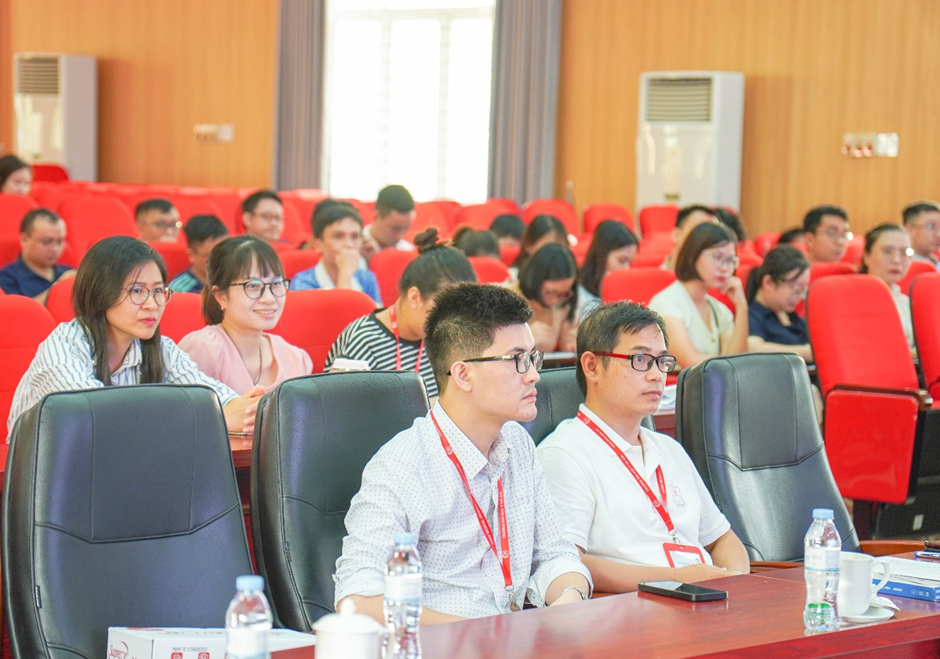 A group of people sitting in a lecture hallDescription automatically generated